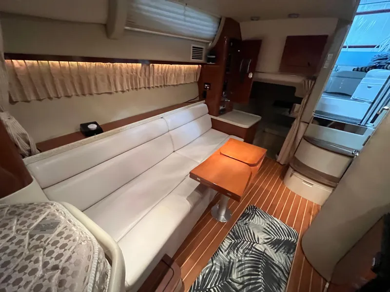 Slide: The Image of Interior of 2006 Regal 3360 Window Express yacht with white seating and wooden accents. - 8