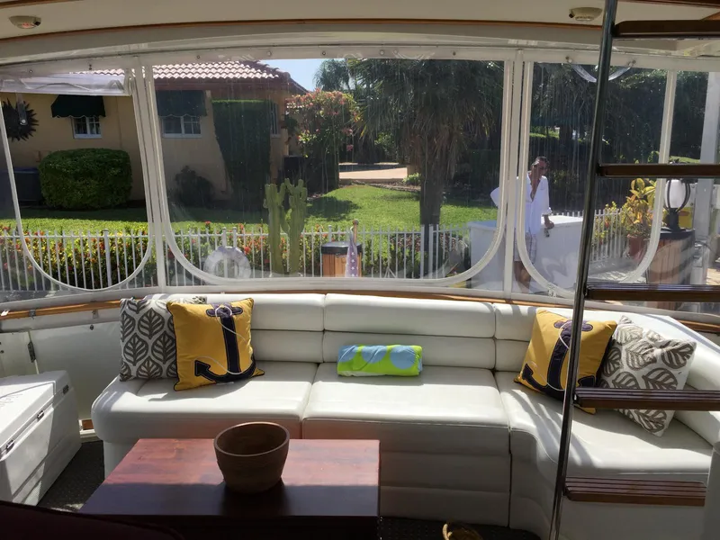 Slide: The Image of 1987 Bertram Motor Yacht interior with white seating, decorative pillows, and outdoor view. - 3