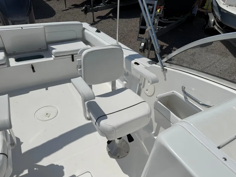 Slide: The Image of 2014 Sea Hunt Escape 211 LE boat interior with white seating and storage compartments. - 10