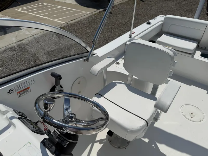 Slide: The Image of 2014 Sea Hunt Escape 211 LE boat interior with steering wheel and seating. - 11