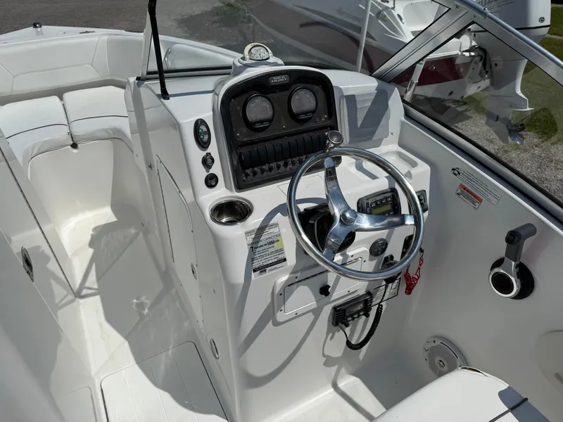 Slide: The Image of 2014 Sea Hunt Escape 211 LE boat cockpit with steering wheel and control panel. - 13
