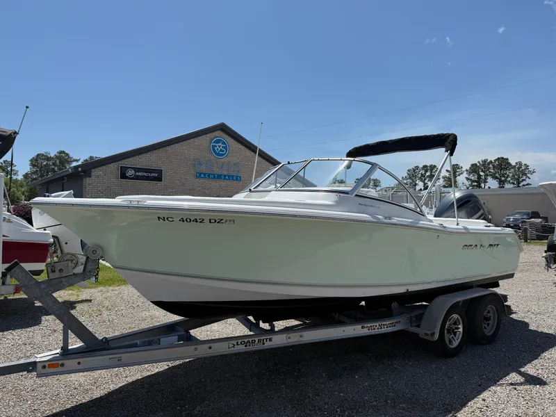 Slide: The Image of 2014 Sea Hunt Escape 211 LE boat on trailer, parked outdoors under clear sky. - 2