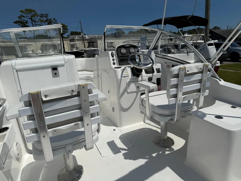Slide: The Image of 2014 Sea Hunt Escape 211 LE boat interior with dual captain chairs and control panel. - 20