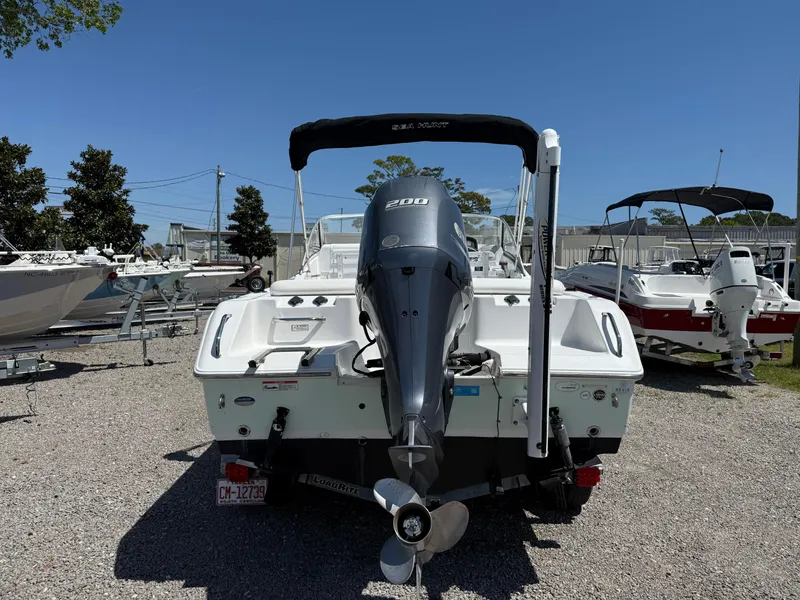 Slide: The Image of 2014 Sea Hunt Escape 211 LE boat with outboard motor, parked on gravel lot. - 4