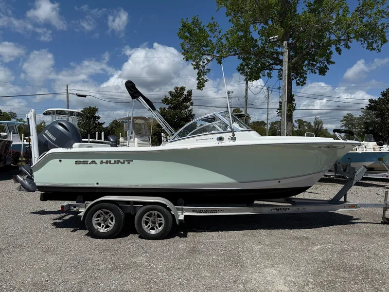Slide: The Image of 2014 Sea Hunt Escape 211 LE boat on trailer, parked outdoors under a clear sky. - 6