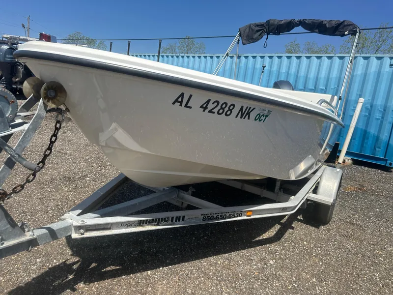 Slide: The Image of 2002 Edgewater 135ST boat on trailer, registration AL 4288 NK, parked outdoors. - 10