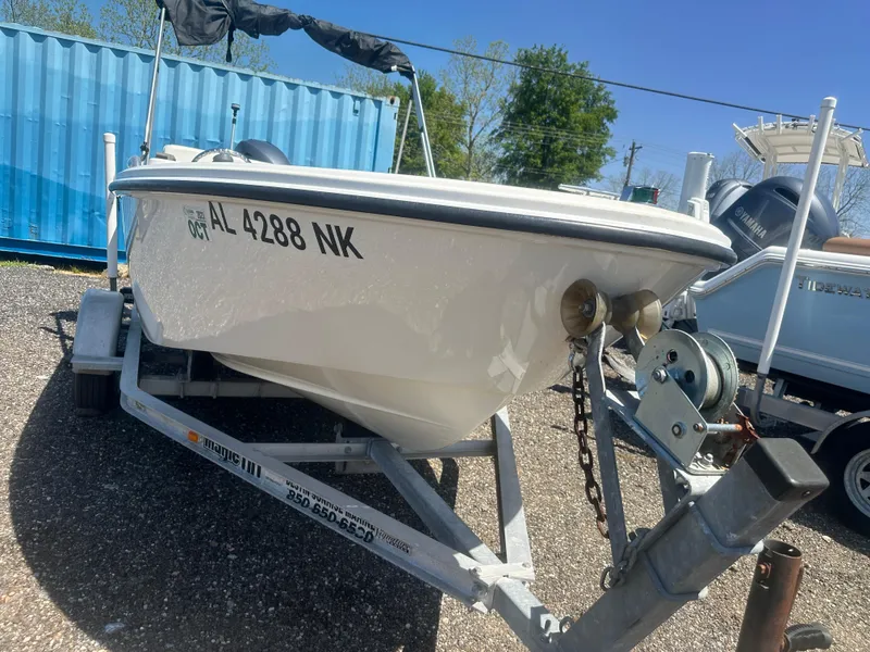 Slide: The Image of 2002 Edgewater 135ST boat on trailer, parked outdoors with blue container background. - 11