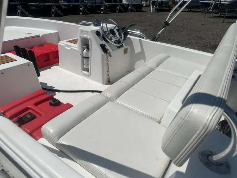 Slide: The Image of 2002 Edgewater 135ST boat interior with white seating and steering console. - 14