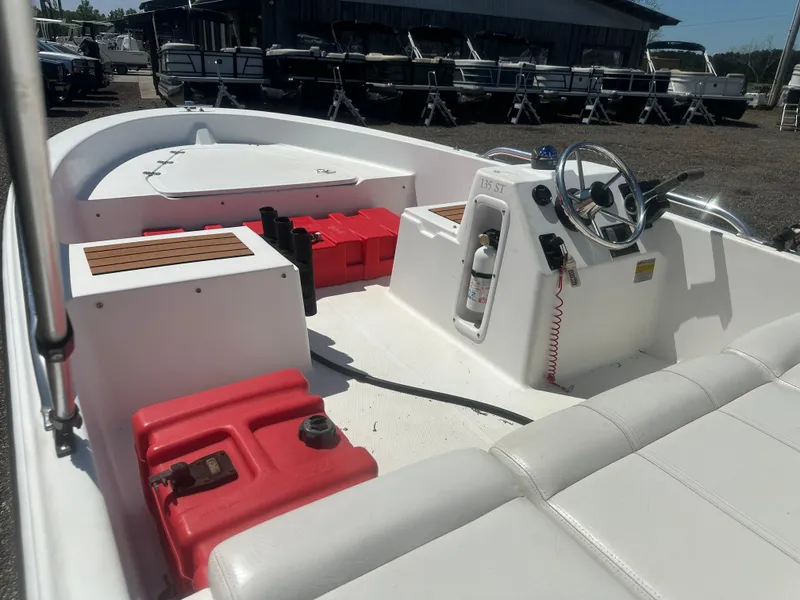 Slide: The Image of 2002 Edgewater 135ST boat interior with steering console and red fuel tanks. - 15
