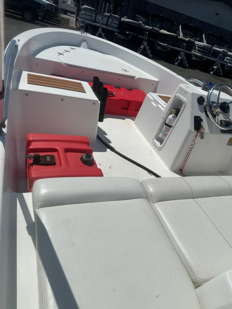 Slide: The Image of 2002 Edgewater 135ST boat interior with white seating and red fuel tanks. - 16