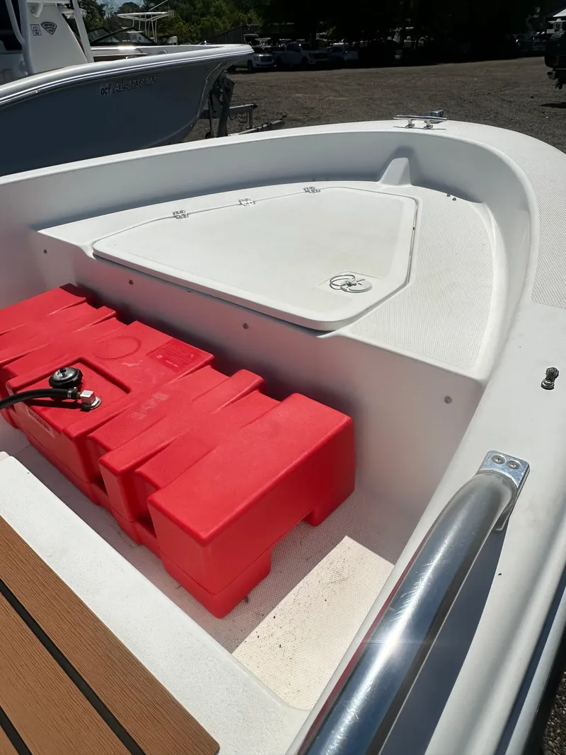 Slide: The Image of 2002 Edgewater 135ST boat interior with red storage compartment and white deck. - 21