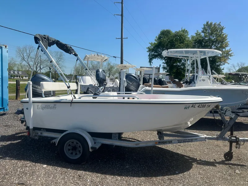 Slide: The Image of 2002 Edgewater 135ST boat on trailer, parked outdoors under clear sky. - 4