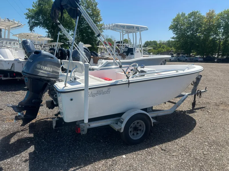 Slide: The Image of 2002 Edgewater 135ST boat on trailer with Yamaha outboard motor, parked outdoors. - 5