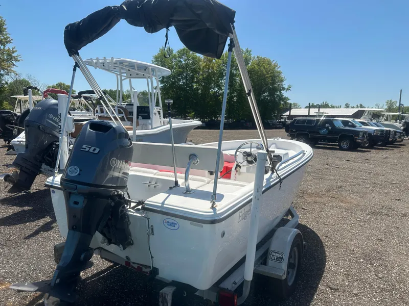 Slide: The Image of 2002 Edgewater 135ST boat with Yamaha 50 engine on a trailer in a parking lot. - 6
