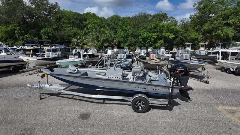 Slide: The Image of 2025 Xpress H20B boat on trailer in outdoor dealership lot. - 11