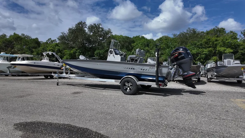 Slide: The Image of 2025 Xpress H20B boat on trailer, parked outdoors under a cloudy sky. - 12