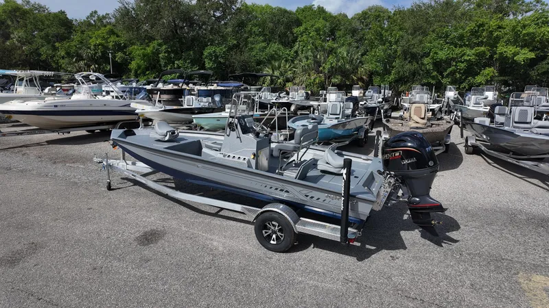 Slide: The Image of 2025 Xpress H20B boat on trailer in a marina with other boats. - 14