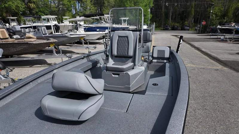 Slide: The Image of 2025 Xpress H20B boat with gray seating, parked in a marina. - 24