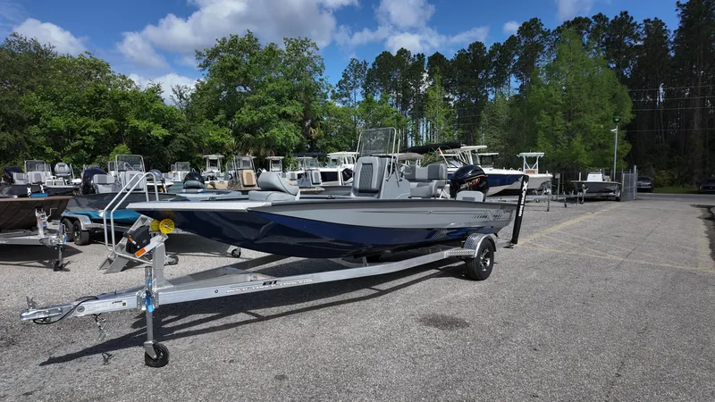 Slide: The Image of 2025 Xpress H20B boat on trailer in outdoor lot with trees and blue sky. - 3