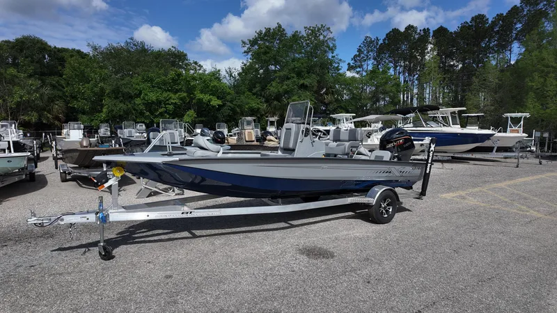 Slide: The Image of 2025 Xpress H20B boat on trailer in outdoor lot with other boats. - 5