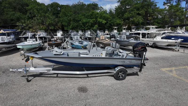 Slide: The Image of 2025 Xpress H20B boat on trailer in marina with multiple boats in background. - 8