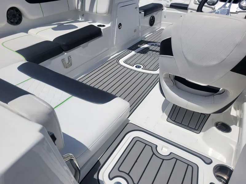 Slide: The Image of 2021 Tahoe 2150 boat interior with white and black seating, gray flooring, and modern design. - 18
