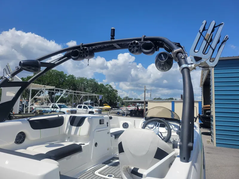 Slide: The Image of 2021 Tahoe 2150 boat interior with wakeboard tower and speakers under a clear blue sky. - 19