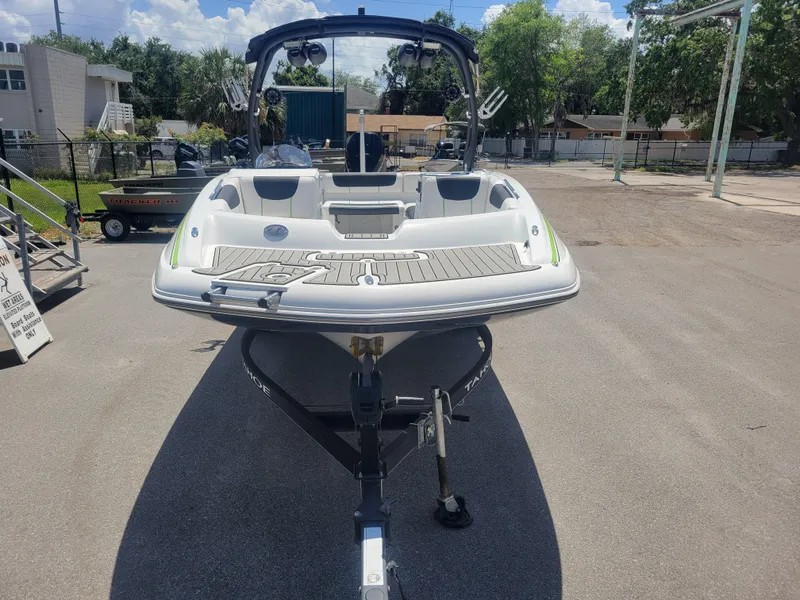 Slide: The Image of 2021 Tahoe 2150 boat on trailer, parked outdoors under clear sky. - 2
