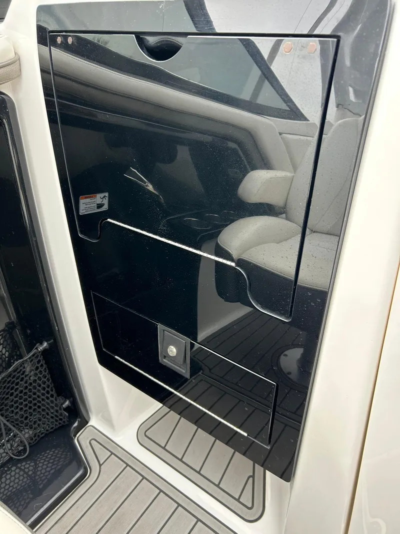 Slide: The Image of 2015 Yamaha Boats 242 Limited S interior storage compartment with sleek black finish. - 14