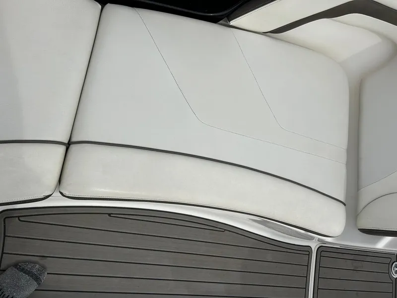 Slide: The Image of 2015 Yamaha Boats 242 Limited S interior seating with sleek white upholstery and gray flooring. - 22
