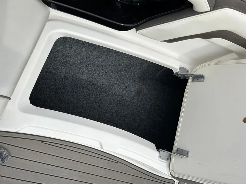 Slide: The Image of Storage compartment in 2015 Yamaha Boats 242 Limited S, featuring a carpeted interior and hinged door. - 24