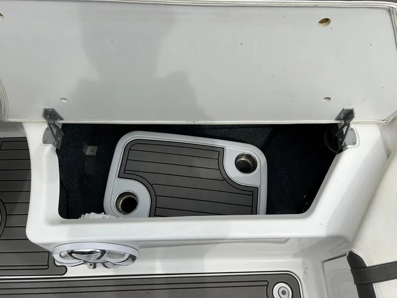 Slide: The Image of Open storage compartment on 2015 Yamaha Boats 242 Limited S, featuring cup holders. - 28