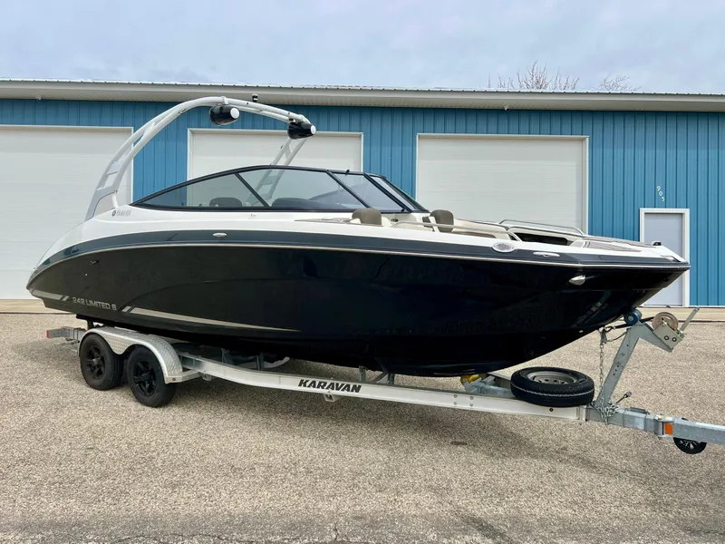 Slide: The Image of 2015 Yamaha Boats 242 Limited S on trailer, parked outside blue building. - 37