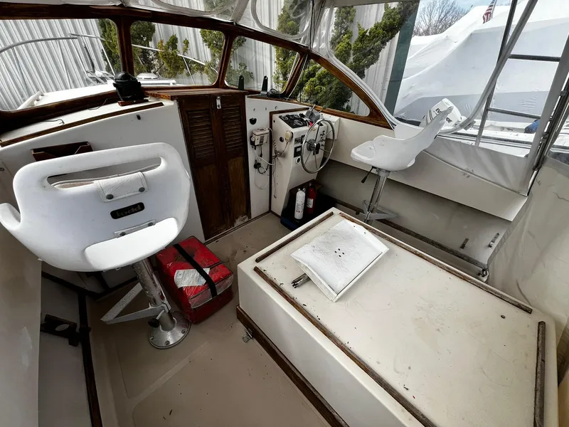 Slide: The Image of 1983 Fortier 26 boat cockpit with white seats, steering wheel, and control panel. - 13
