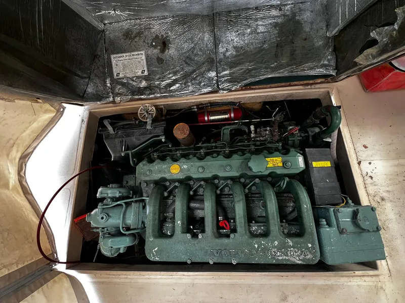 Slide: The Image of Engine compartment of a 1983 Fortier 26 boat, showcasing a vintage marine engine. - 15