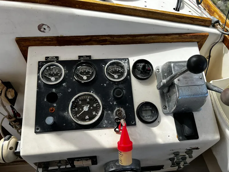 Slide: The Image of Control panel of a 1983 Fortier 26 boat with gauges and throttle lever. - 17