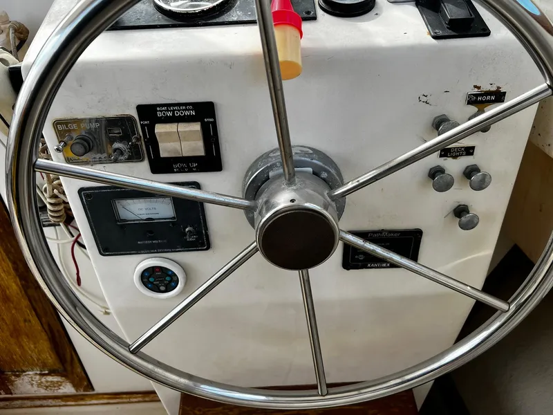 Slide: The Image of Steering wheel and control panel of a 1983 Fortier 26 boat. - 18