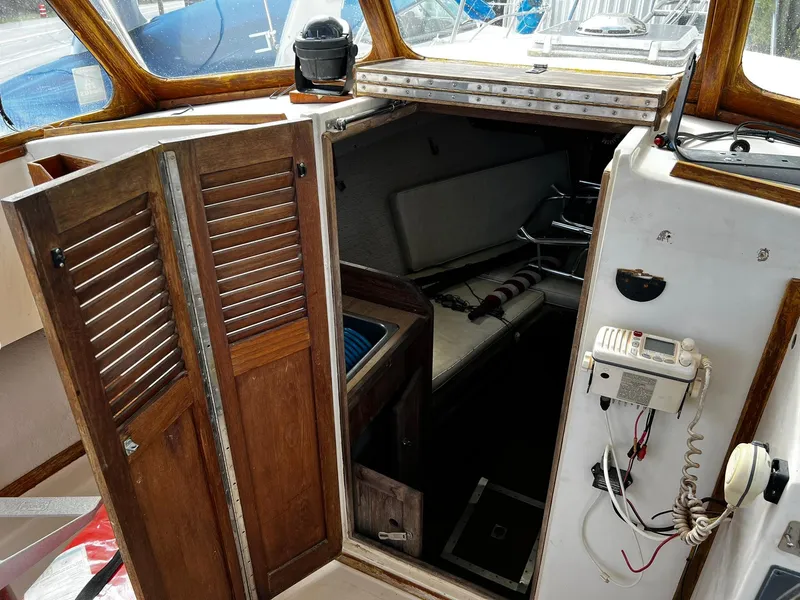 Slide: The Image of 1983 Fortier 26 boat cabin interior with wooden doors and nautical equipment. - 22