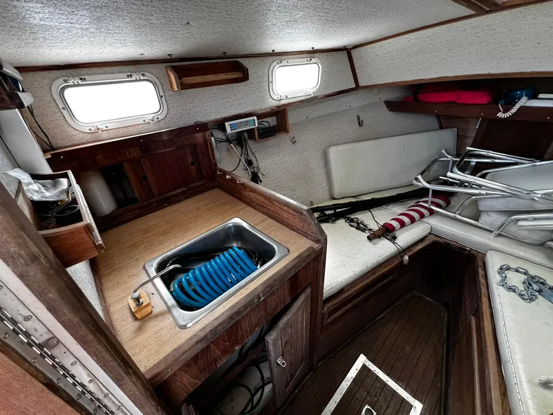 Slide: The Image of Interior of 1983 Fortier 26 boat with wooden cabinetry and compact kitchen area. - 23