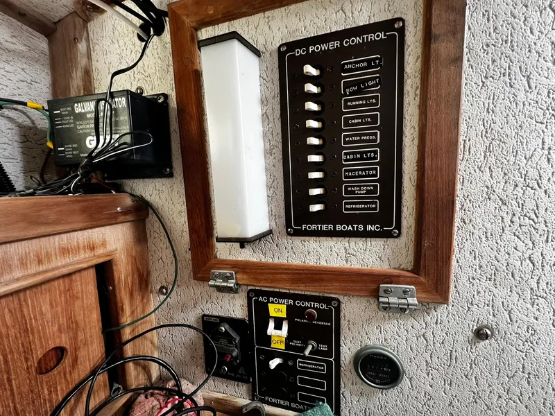 Slide: The Image of Electrical control panel on a 1983 Fortier 26 boat, featuring DC and AC power switches. - 25