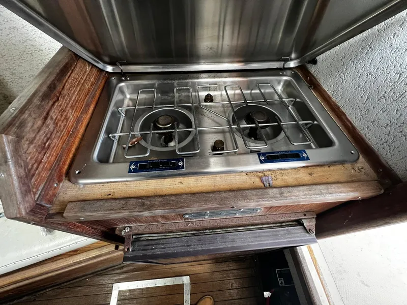 Slide: The Image of Stainless steel stove on 1983 Fortier 26 boat with wooden cabinetry. - 27