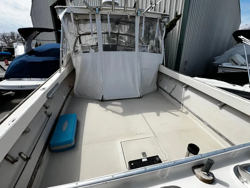 Slide: The Image of 1983 Fortier 26 boat with open deck, canopy, and blue cooler. - 28