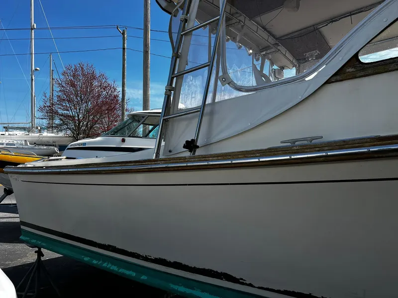 Slide: The Image of 1983 Fortier 26 boat with white hull and clear canopy, docked outdoors. - 4