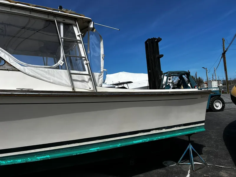 Slide: The Image of 1983 Fortier 26 boat on stands, with a clear blue sky background. - 7
