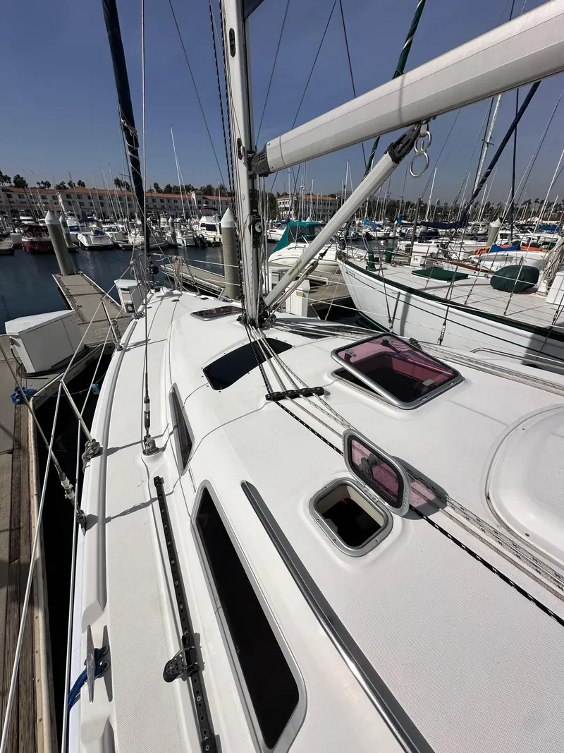 Slide: The Image of 2008 Hunter 38 sailboat docked at marina, showcasing deck and rigging. - 13