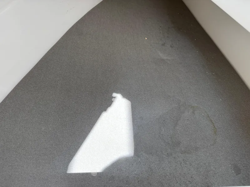 Slide: The Image of 2024 Robalo R317 boat interior with gray upholstery and a small tear. - 20