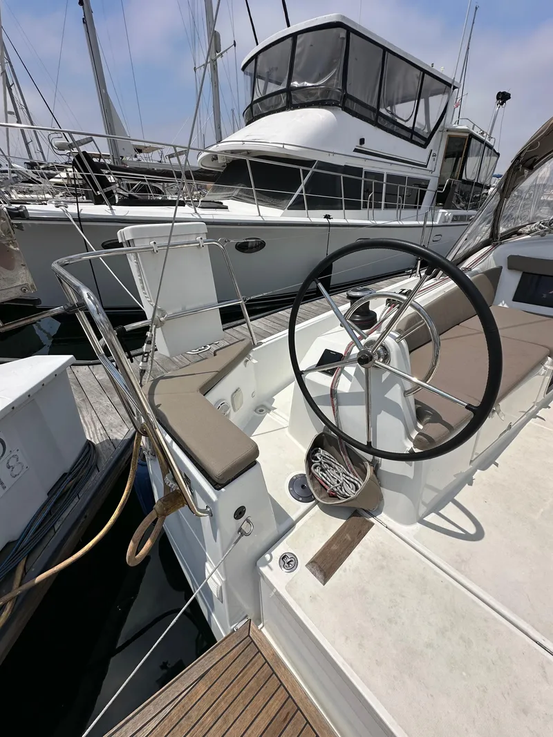 Slide: The Image of 2020 Jeanneau Sun Odyssey 410 sailboat cockpit with steering wheel, docked at marina. - 20