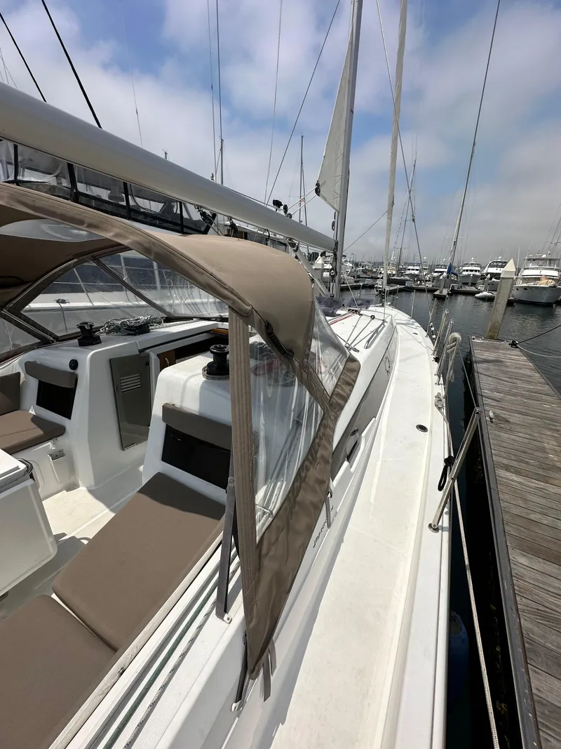 Slide: The Image of 2020 Jeanneau Sun Odyssey 410 sailboat docked at marina, showcasing sleek design and spacious deck. - 24