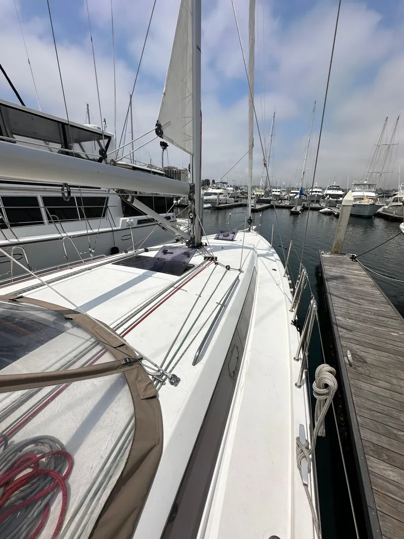 Slide: The Image of 2020 Jeanneau Sun Odyssey 410 sailboat docked at marina, clear sky, calm waters. - 25