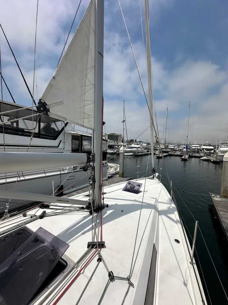 Slide: The Image of 2020 Jeanneau Sun Odyssey 410 sailboat docked in a marina under a clear sky. - 26